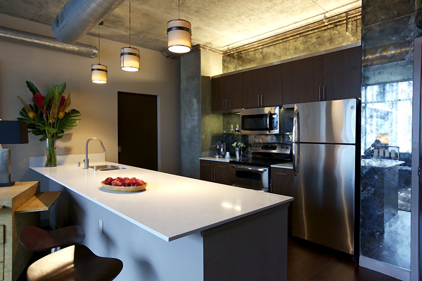 Downtown LA furnished apartment gourmet kitchen with pendant lights, quartz island, and stainless steel appliances