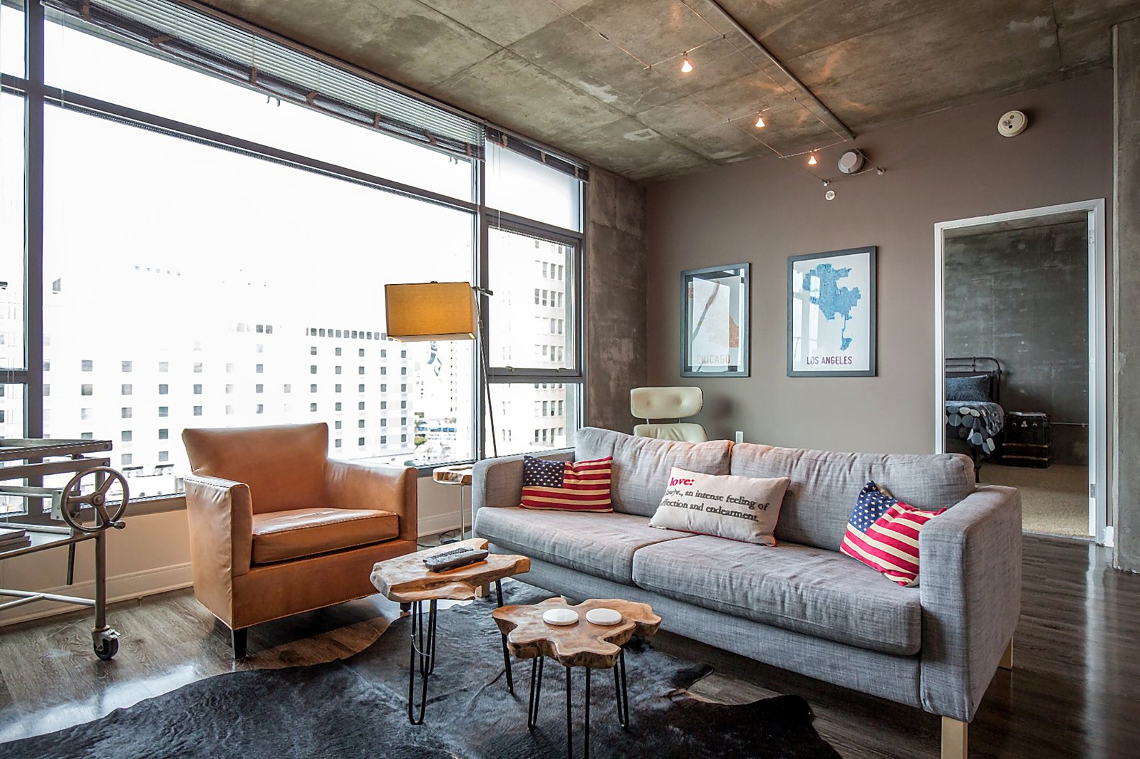 Downtown LA corporate housing industrial-chic living room with floor-to-ceiling windows and city skyline views