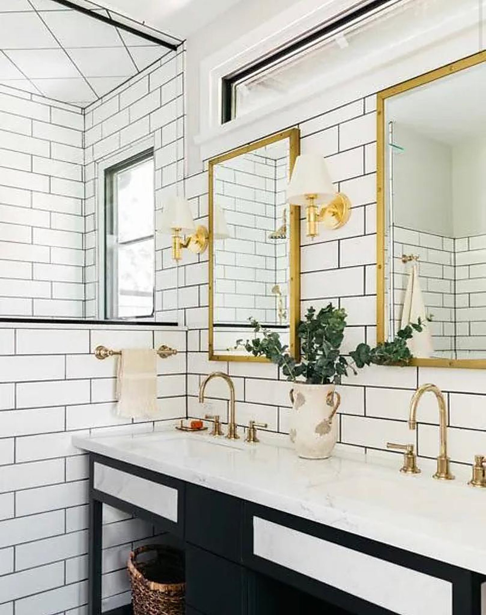 Double vanity bathroom with gold mirrors and brass sconces in Santa Monica